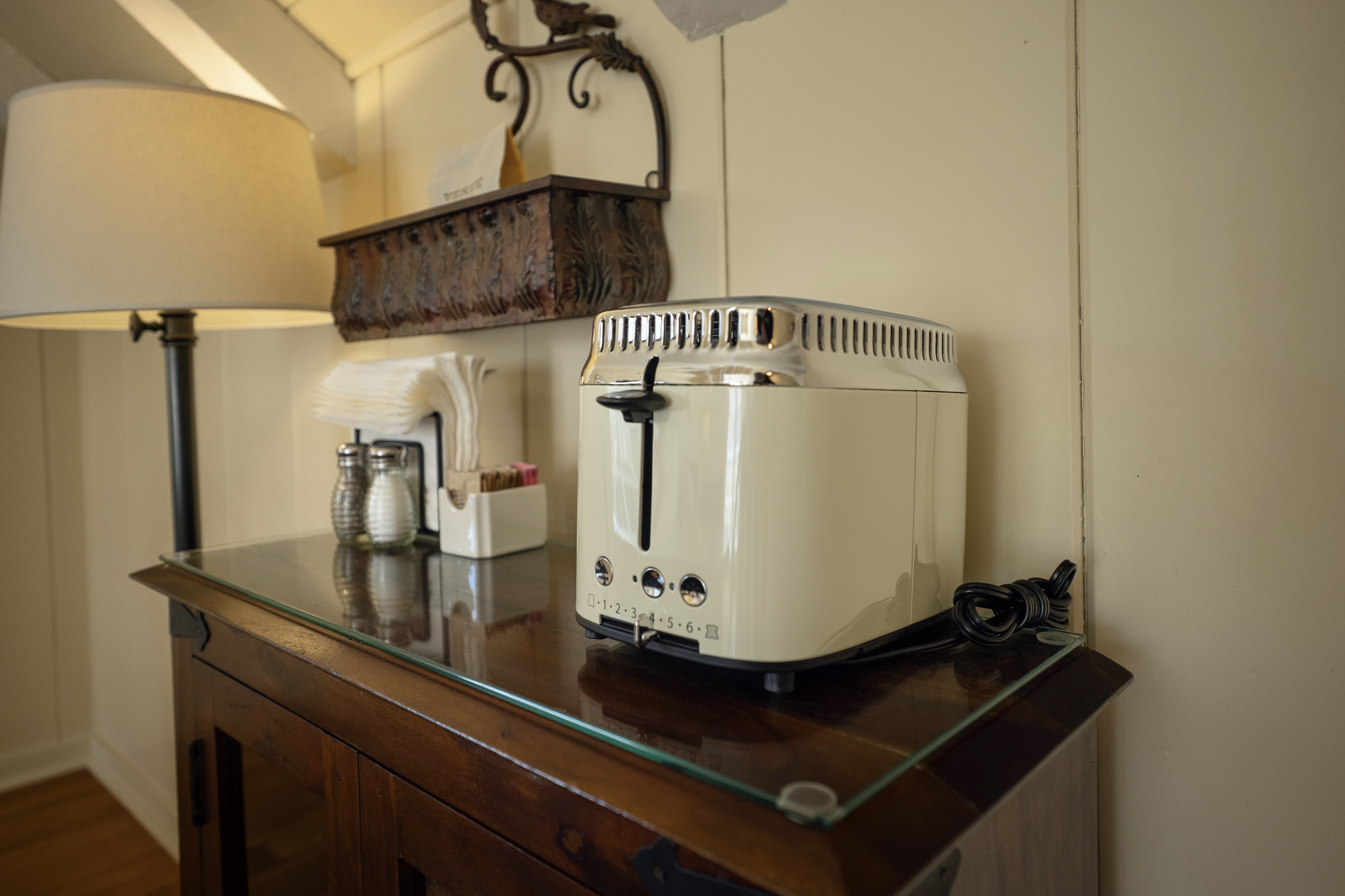 Close up view of a retro toaster, side table and lamp.