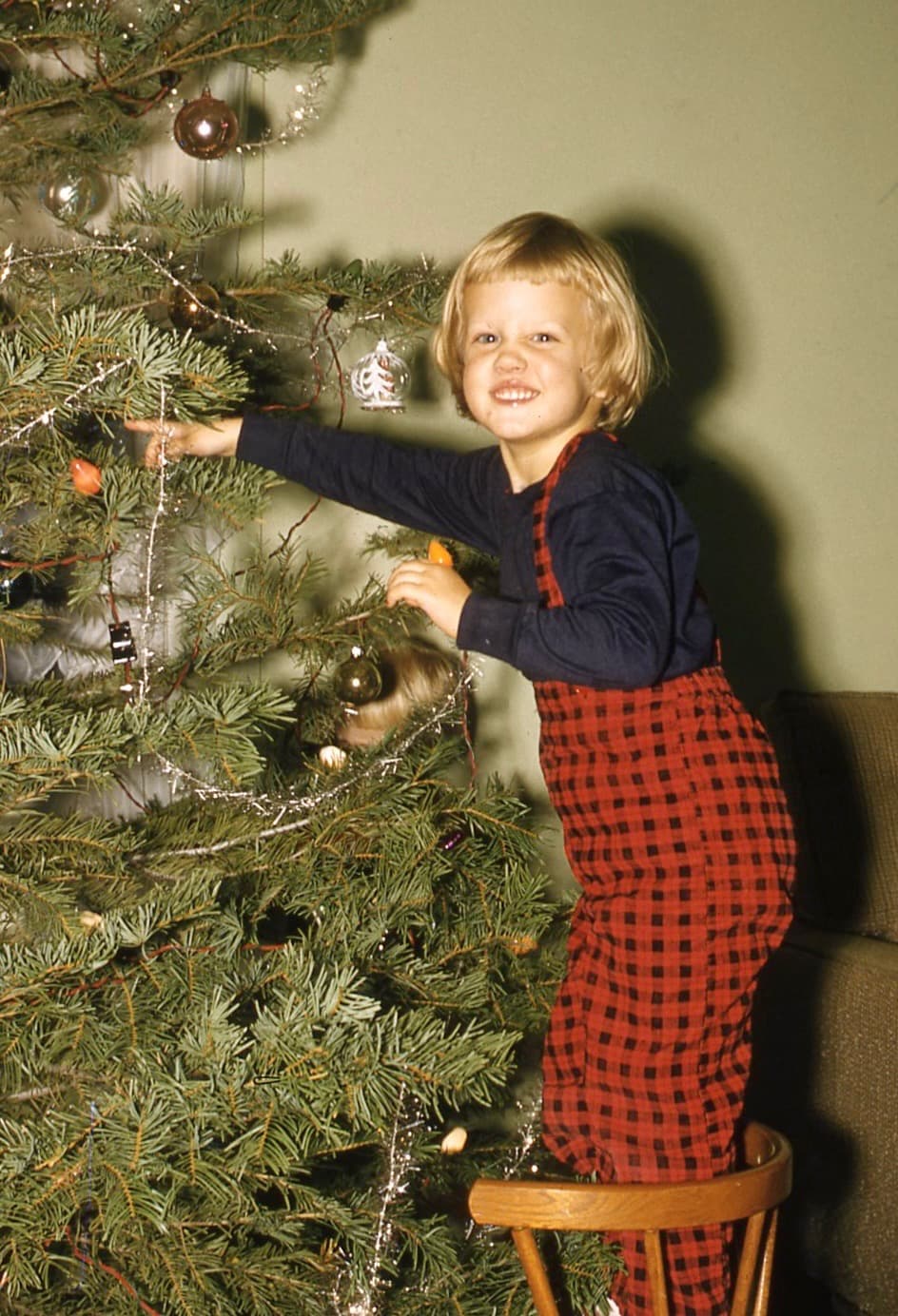 Cheryl decorating a Christmas tree as a child.