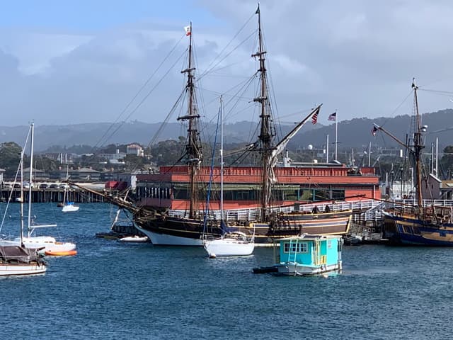 Ship and boats in the water behind the Monterey Wharf.